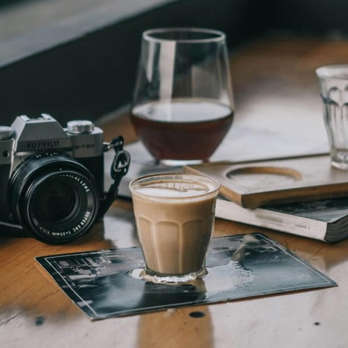 a camera and cup of coffee on a table