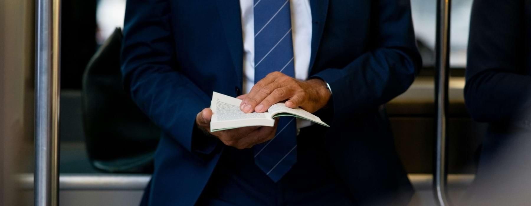 a man in a suit holding a book